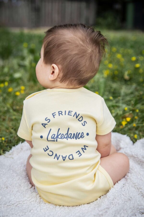 Lakedance merchandise baby romer geel achterkant.